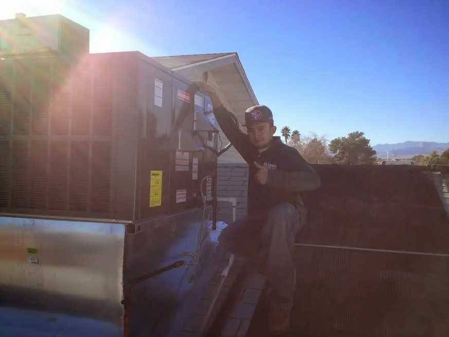 HVAC technician performing Air Duct Cleaning on a rooftop unit in Townsend